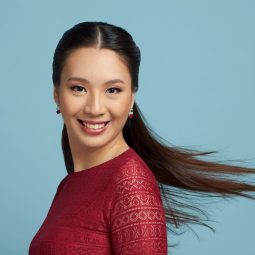 Straight hair ideas: Asian woman with long black hair in a half updo smiling