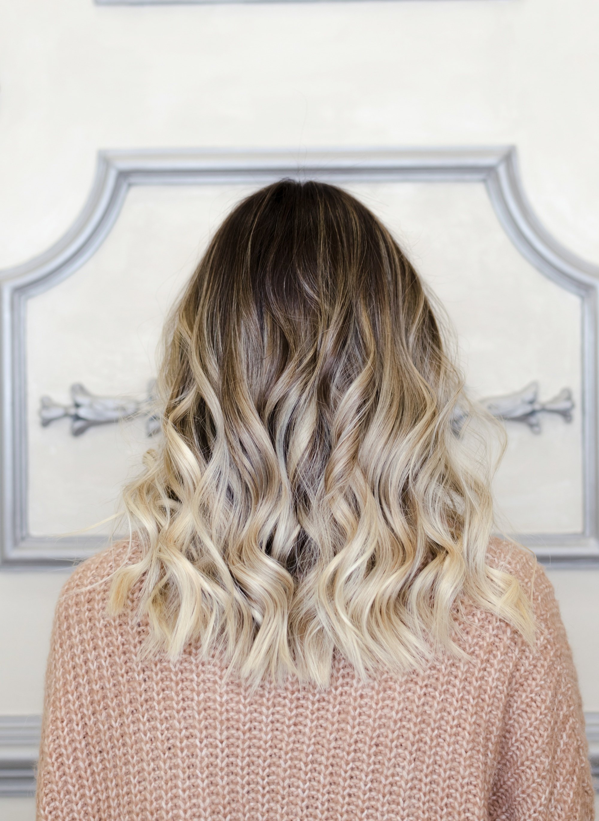 Back shot of a woman with wavy balayage hair