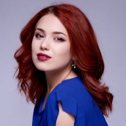 Shampoo and conditioner for colored hair: Woman with burgundy hair wearing a blue top