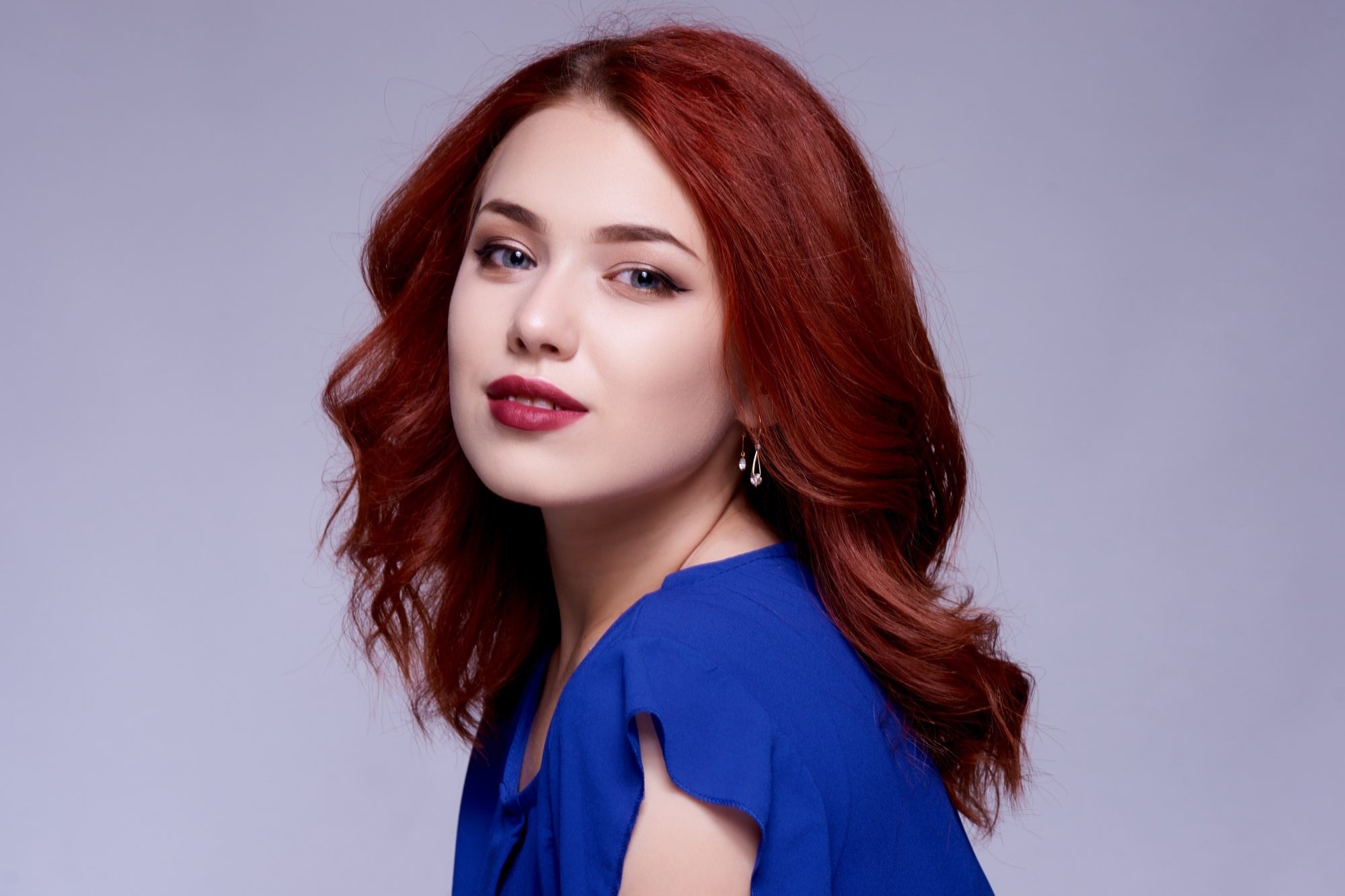 Shampoo and conditioner for colored hair: Woman with burgundy hair wearing a blue top
