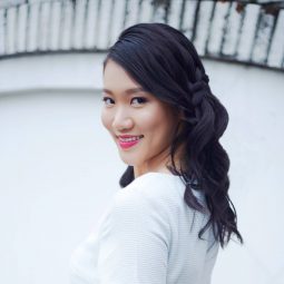 V-shape haircut: Asian woman with hair in waterfall braid smiling and wearing a white dress