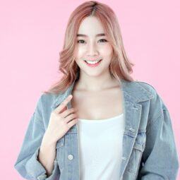 Bleached hair colors: Asian woman with long pink hair smiling