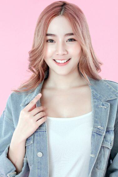 Bleached hair colors: Asian woman with long pink hair smiling
