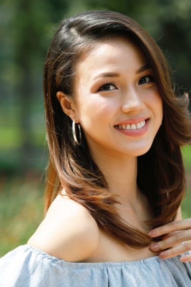 Bouncy brown layered hair: an Asian woman outdoors, smiling with her beautiful brown hair