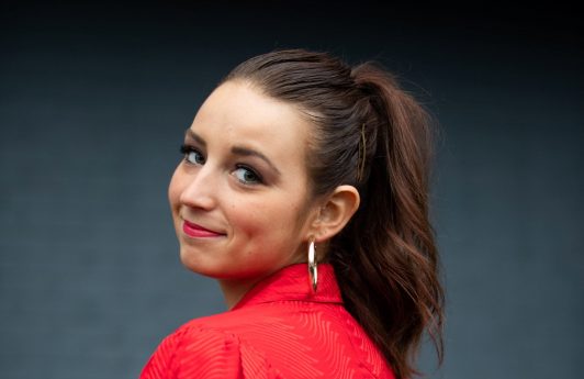 Caucasian woman with long brown hair in a high ponytail shot street style