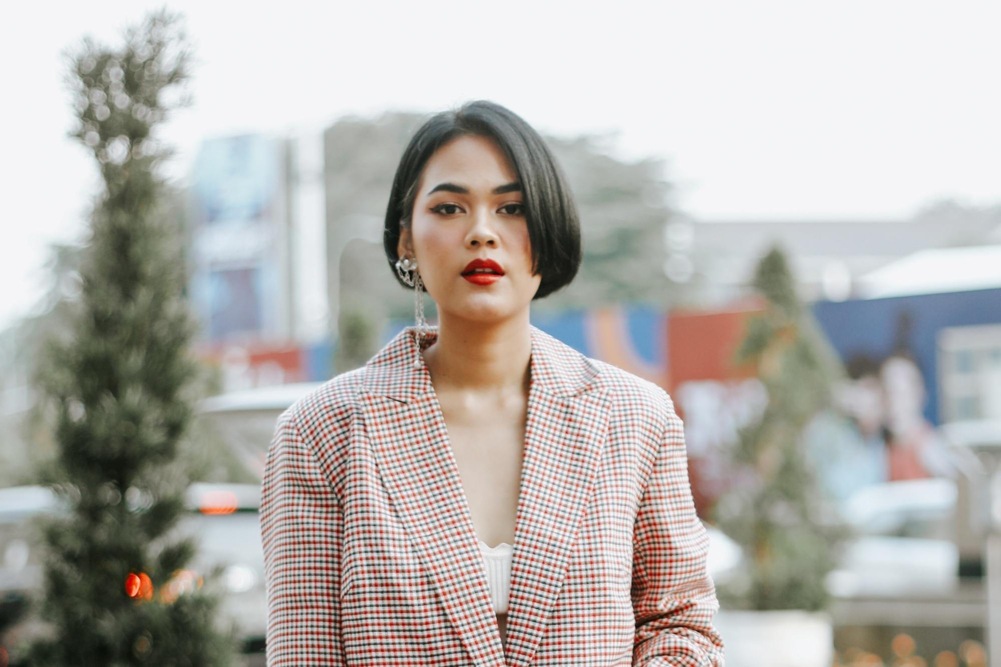 Asian woman with short straight hair wearing a beige jacket
