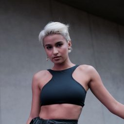 Issa Pressman: A Filipina with short blonde hair wearing a black cropped halter top posing outdoors