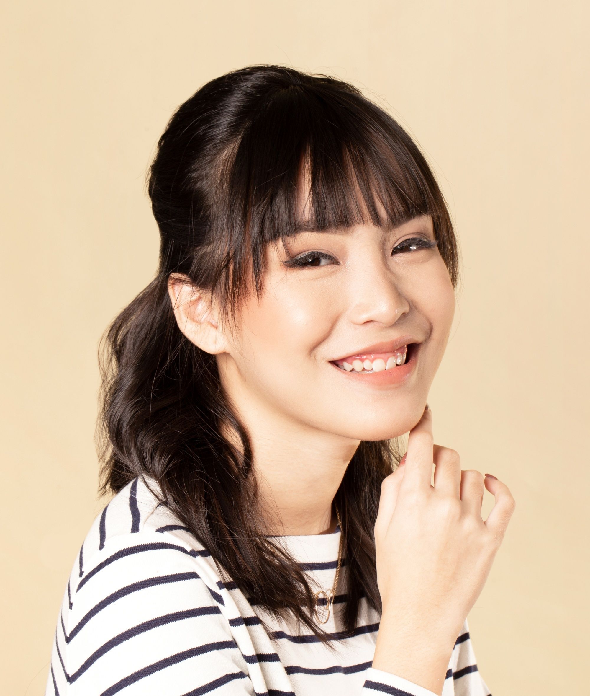Asian woman with short hair in a half updo with bangs