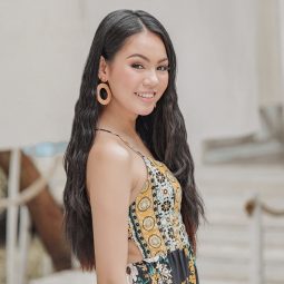 Asian woman with long wavy hair wearing a sleeveless printed top