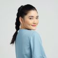 Asian woman with braid ponytail wearing a light blue blouse