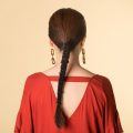 Back shot of an Asian woman with long hair wearing a red dress