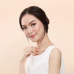 Bridesmaid hairstyle: Asian woman with an elegant updo wearing a white sleeveless dress