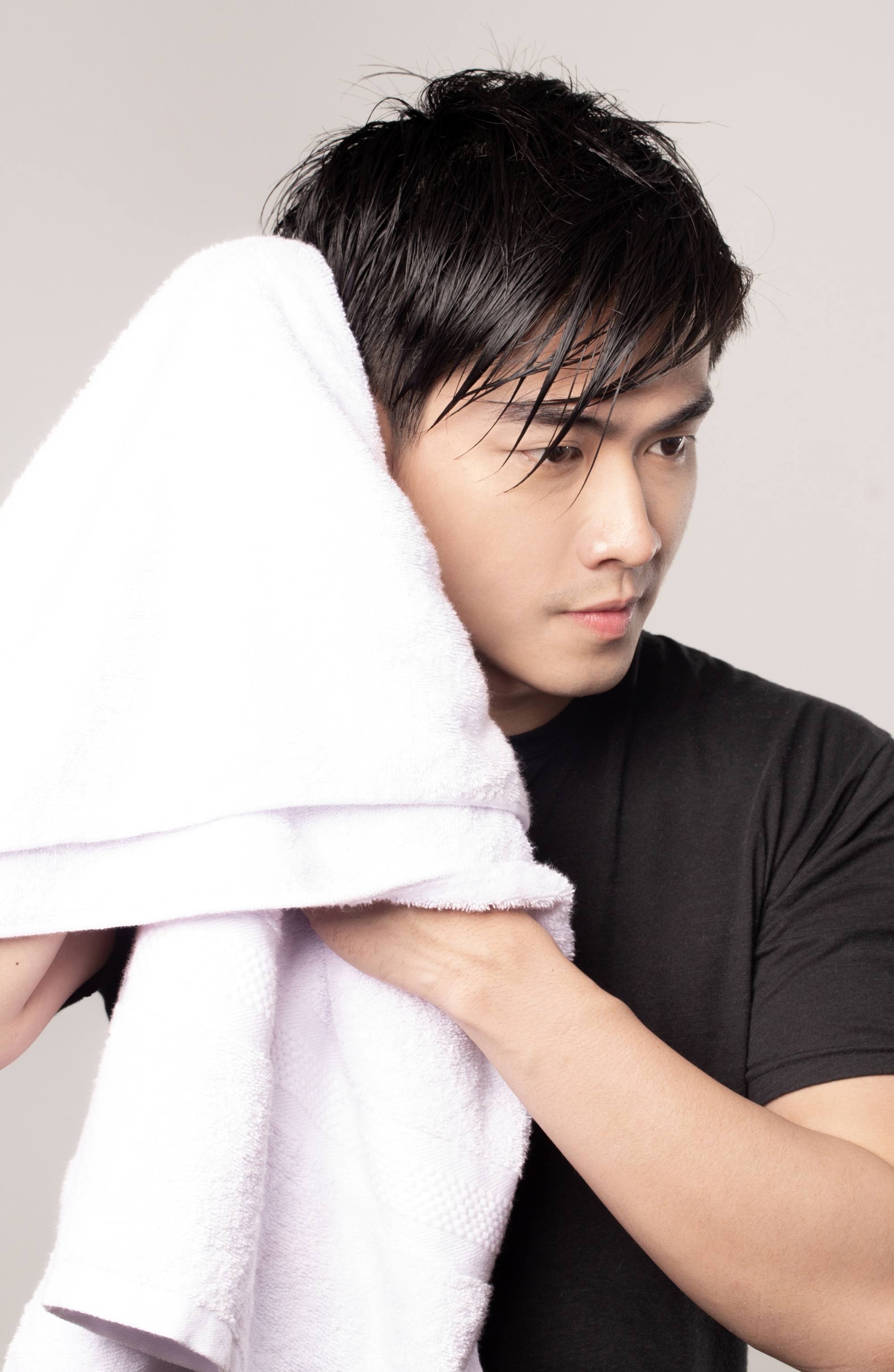Asian man towel drying her wet hair after showering