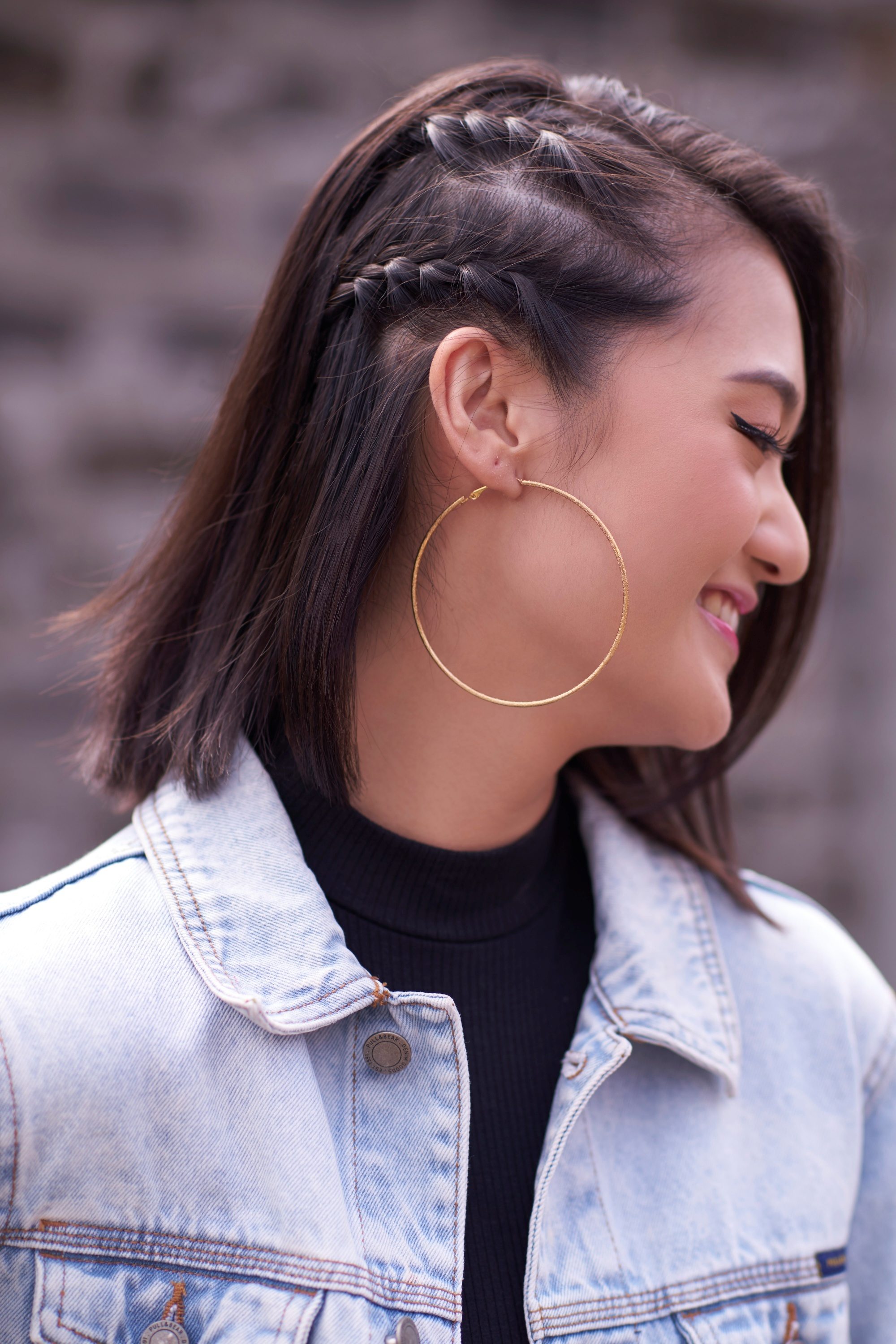 Asian woman with a braided bob wearing a denim jacket