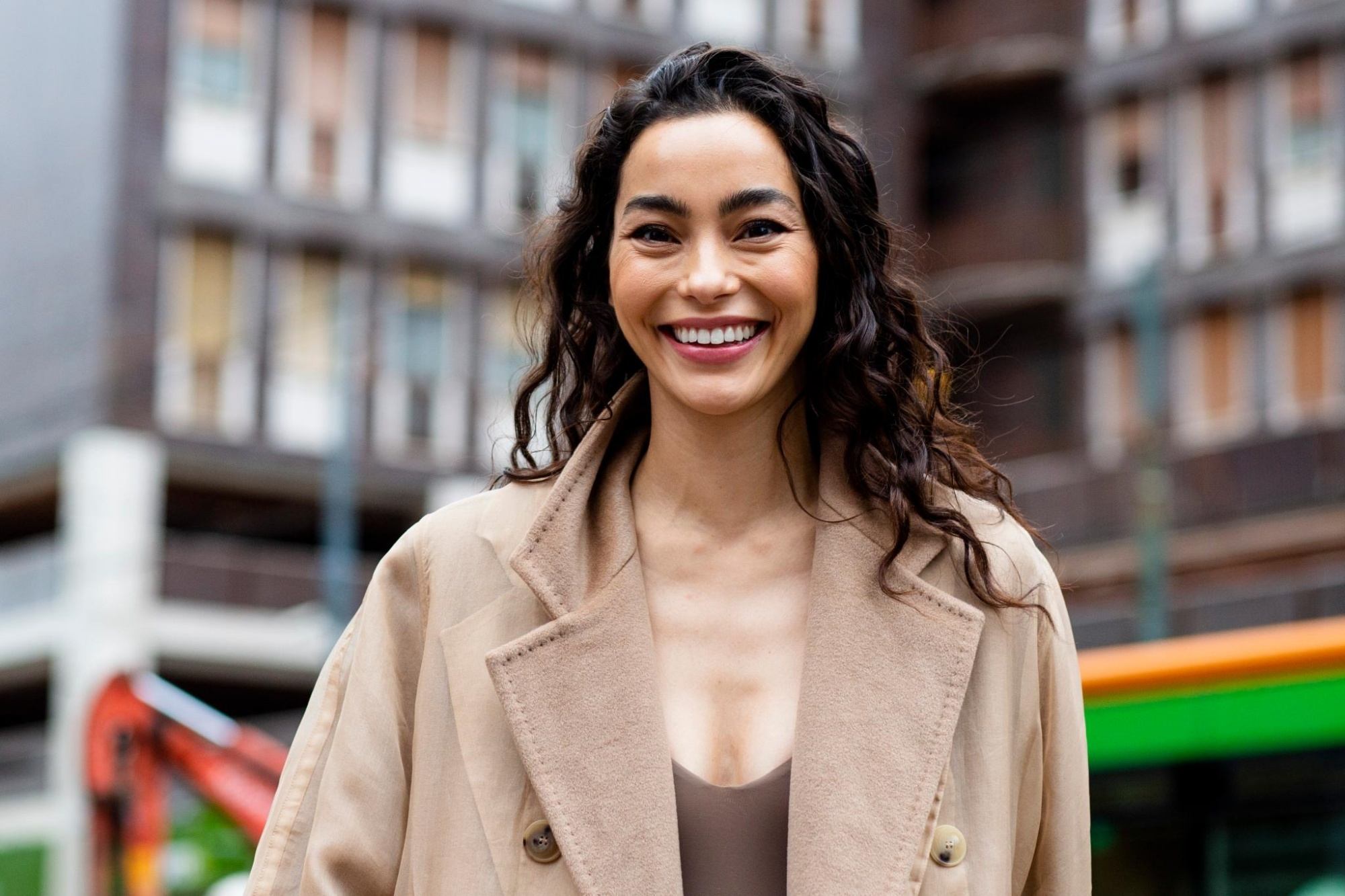 Woman with dark espresso hair wearing a light beige coat