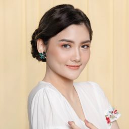 Asian woman with twisted updo hairstyle wearing a white dress