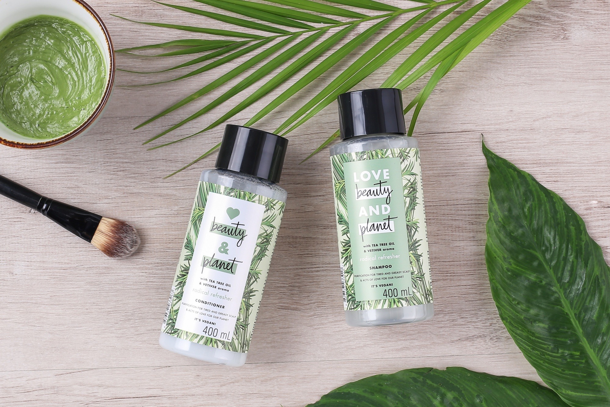 Ashfall hair care tips: Flat lay of shampoo and conditioner with leaves