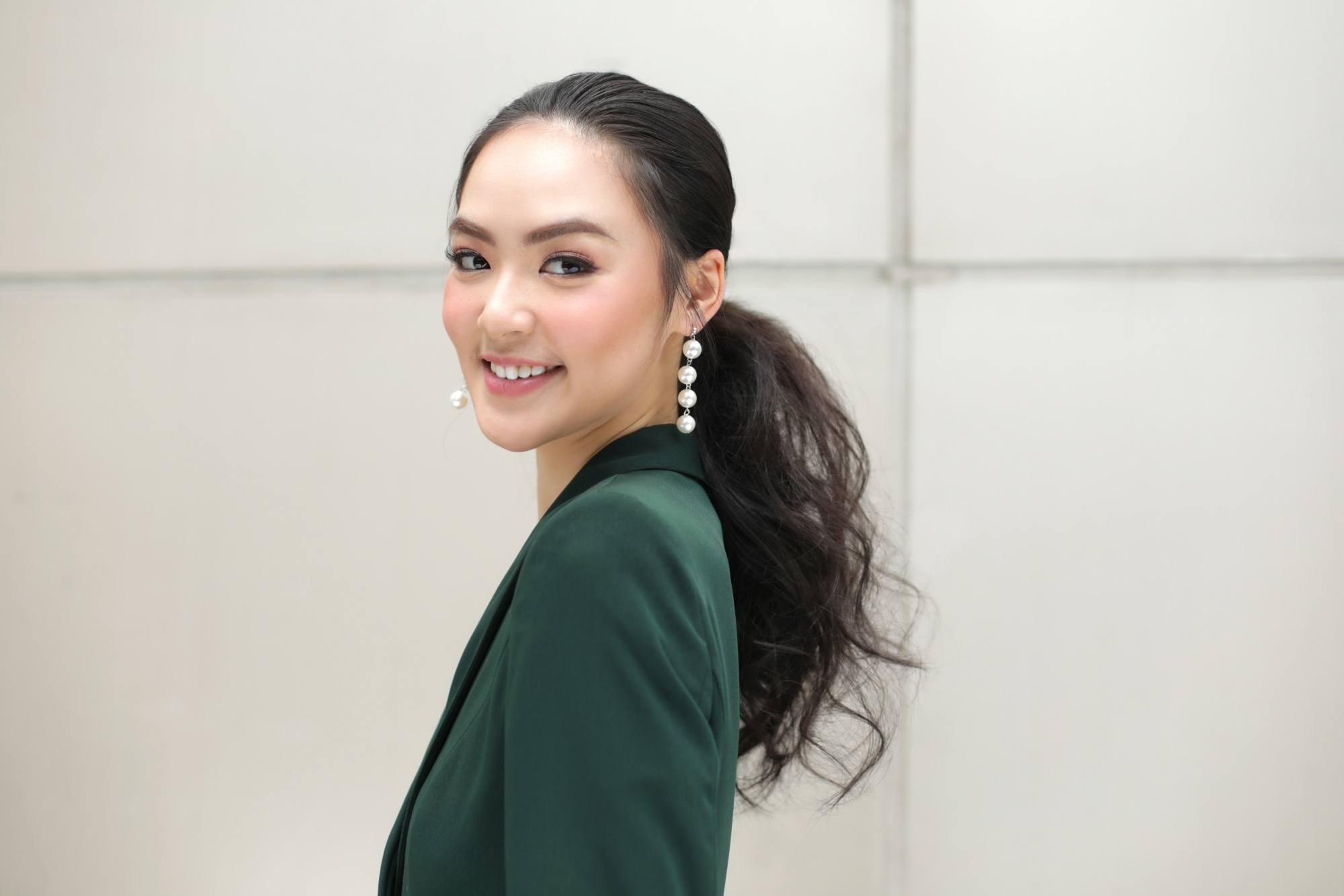 Asian woman with long hair in a tousled low ponytail