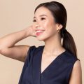 Asian woman with a low vintage ponytail wearing a dark blue blouse