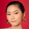 Asian woman with a slicked-back pixie cut haristyle