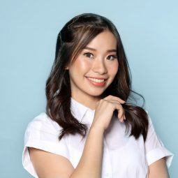 Dry and damaged hair: Asian woman with long black hair wearing a white blouse against a blue background