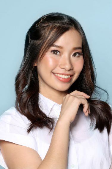 Dry and damaged hair: Asian woman with long black hair wearing a white blouse against a blue background