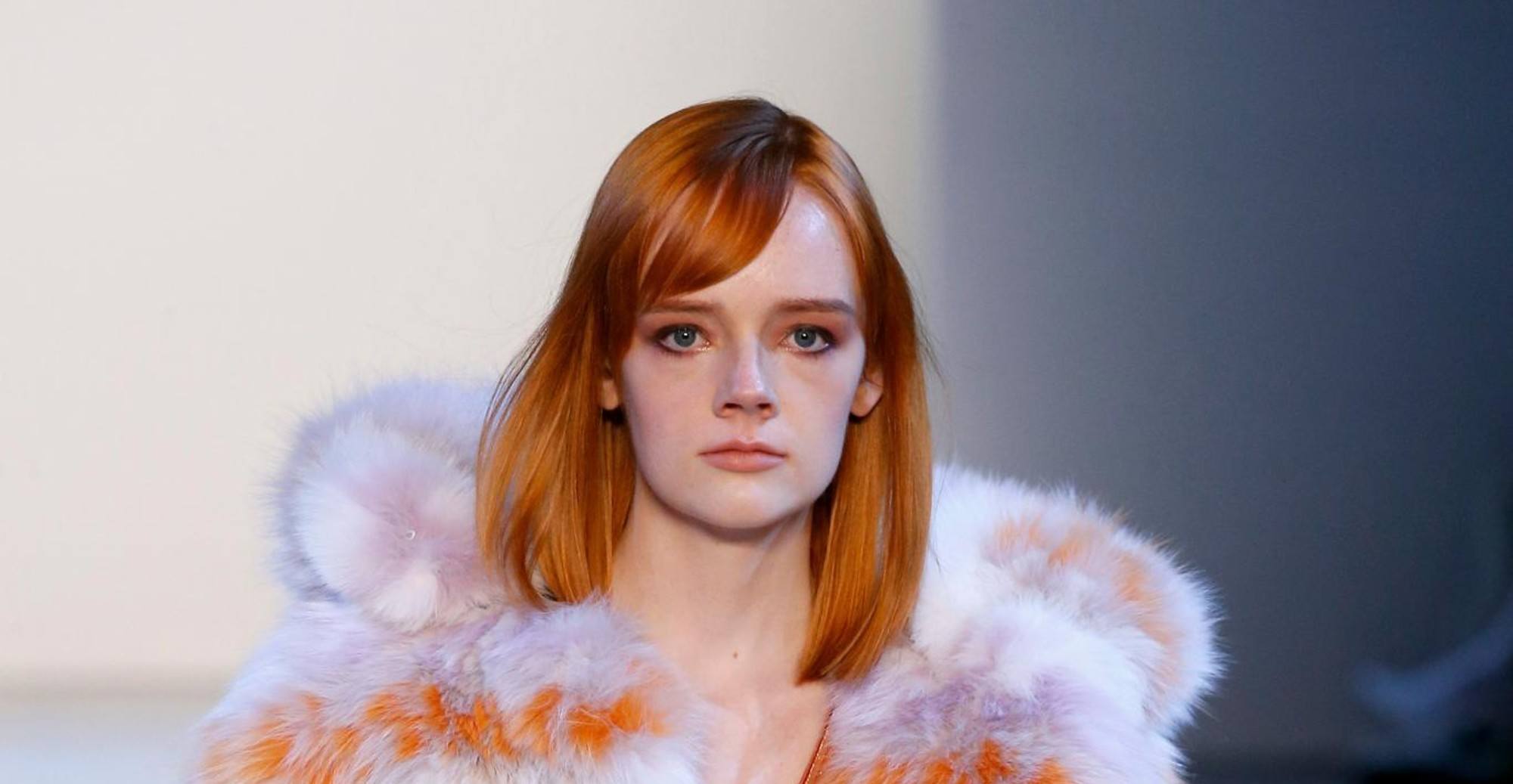 Model is wearing copper colored hair that has side bangs