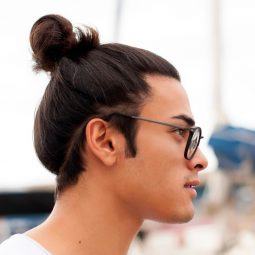 Side view of a man with long hair in a man bun wearing eyeglasses
