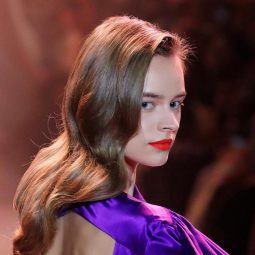 Model with long hair wearing a purple dress at the New York Fashion Week