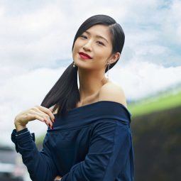 Asian woman with beautiful summer hair in a side ponytail wearing an off-shoulder top