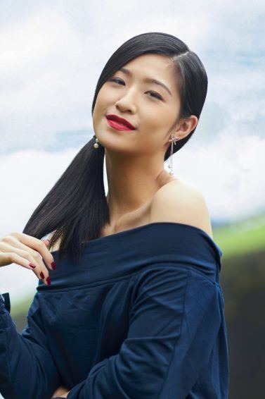 Asian woman with beautiful summer hair in a side ponytail wearing an off-shoulder top