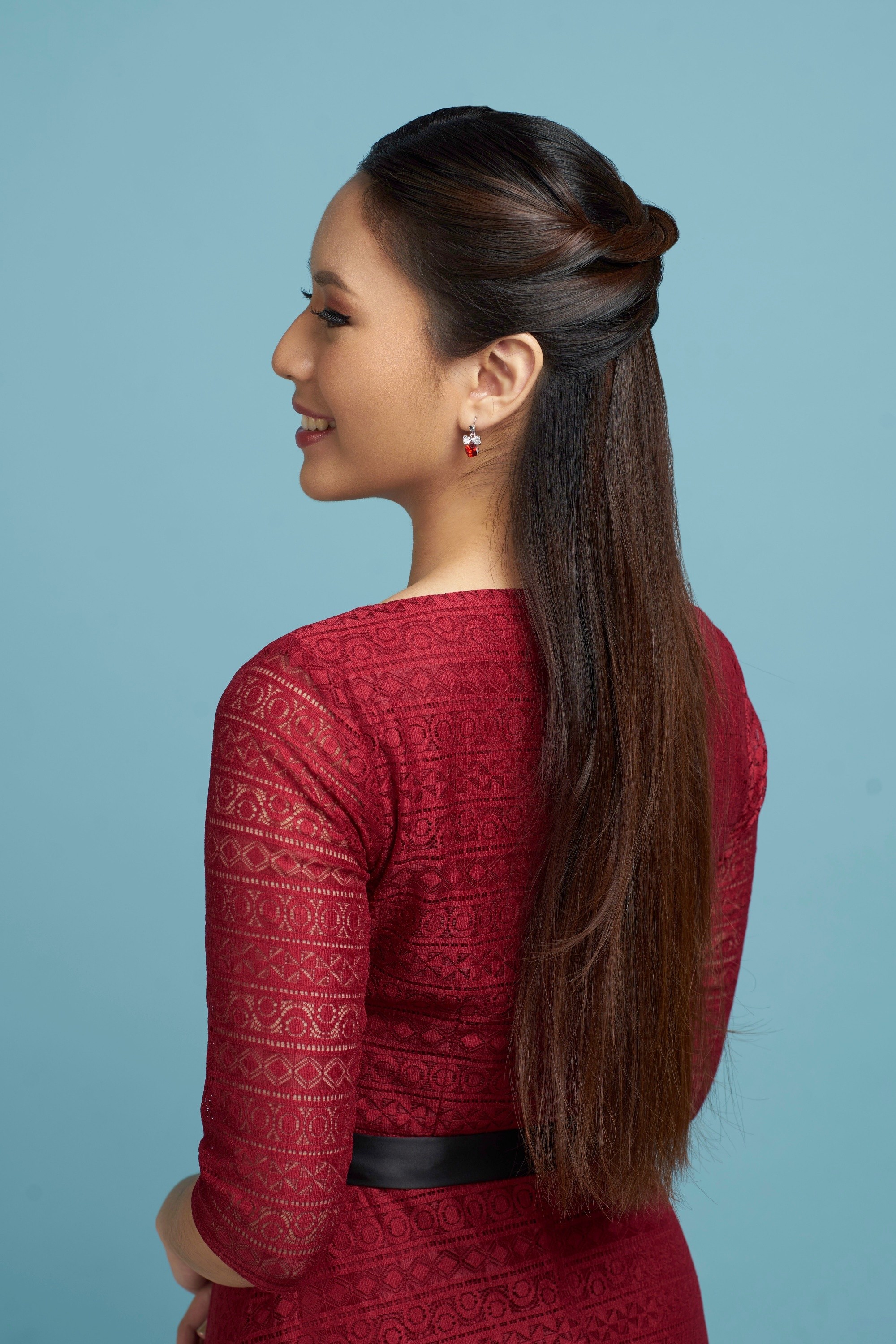Asian woman with a half up criss cross Valentine hairstyle wearing a red dress