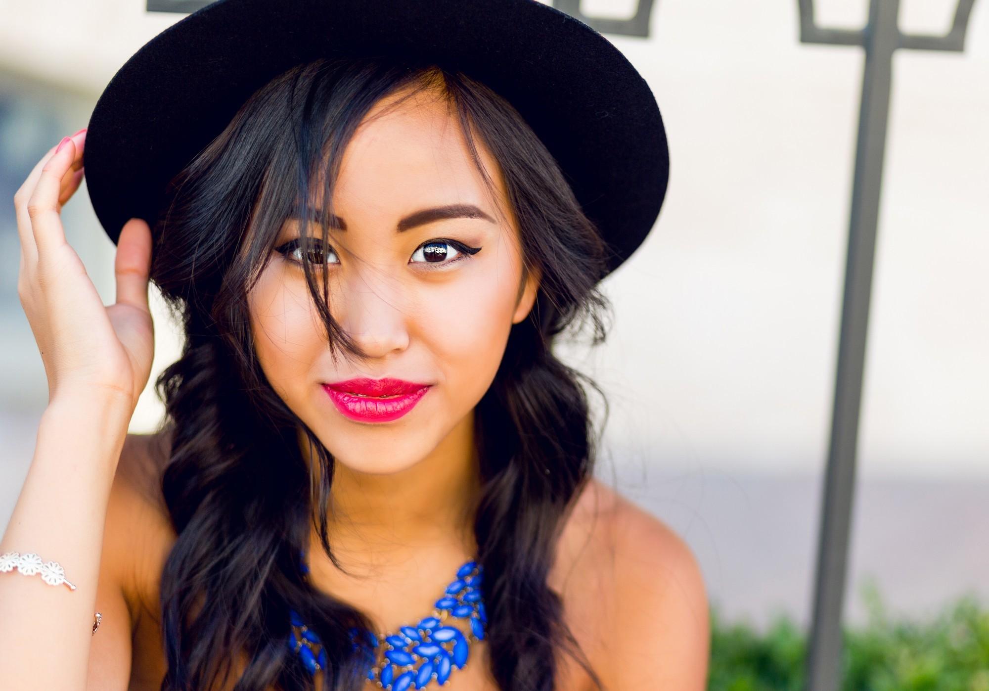 girl is wearing a hat on her long and black hair
