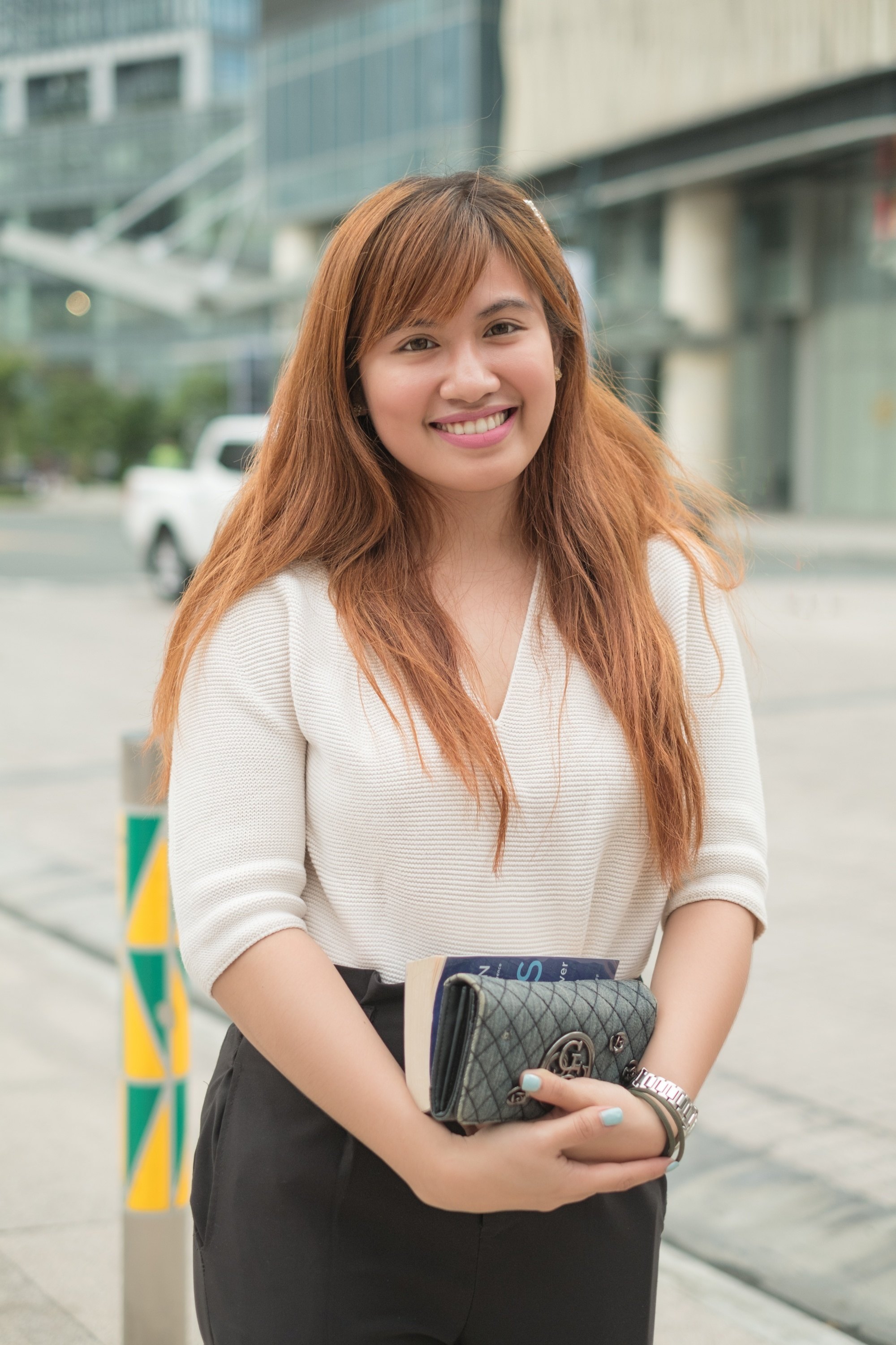 Asian woman with long cinnamon brown hair with side-swept bangs