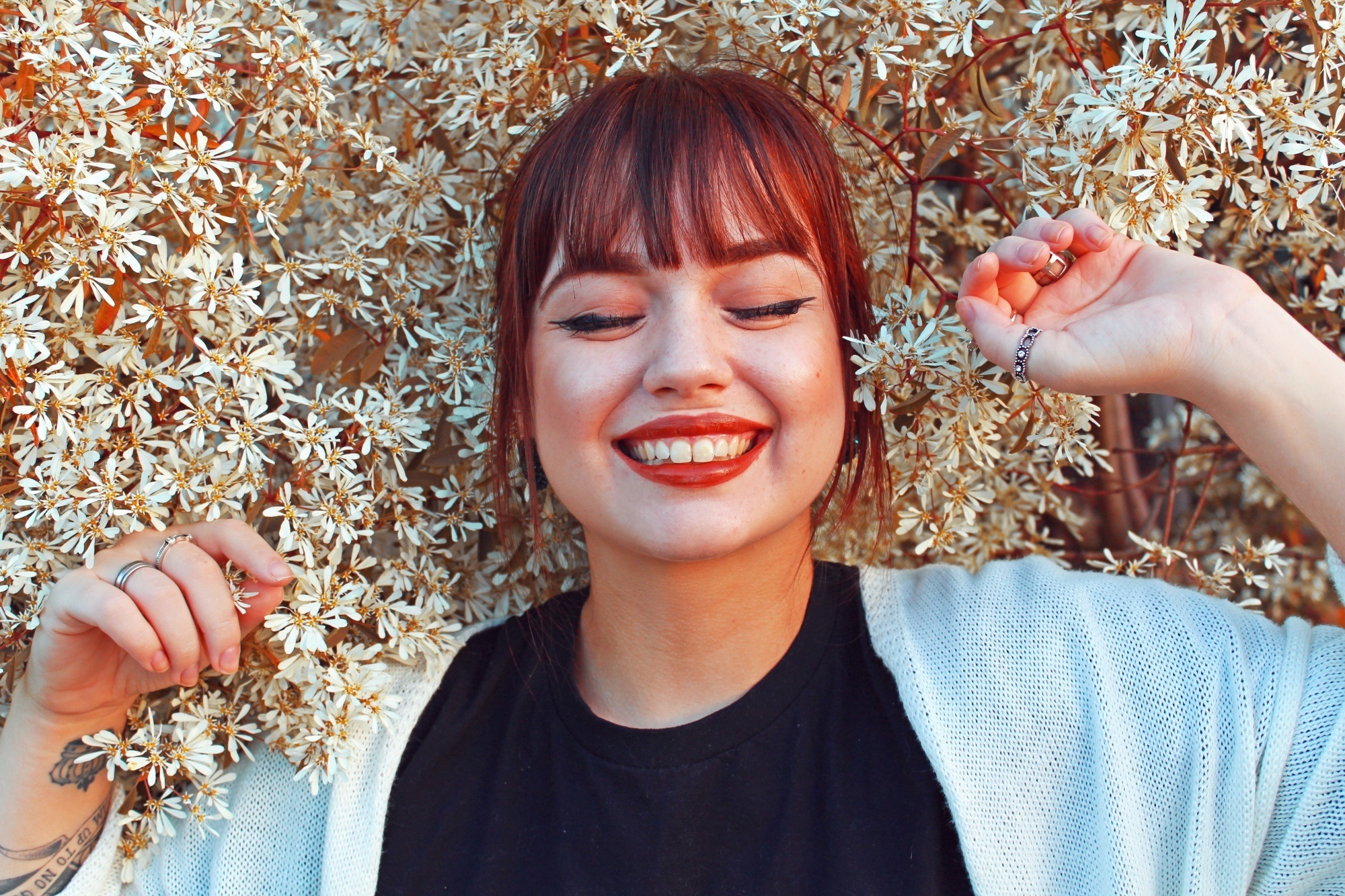 Woman with burgundy hair and bangs smiling