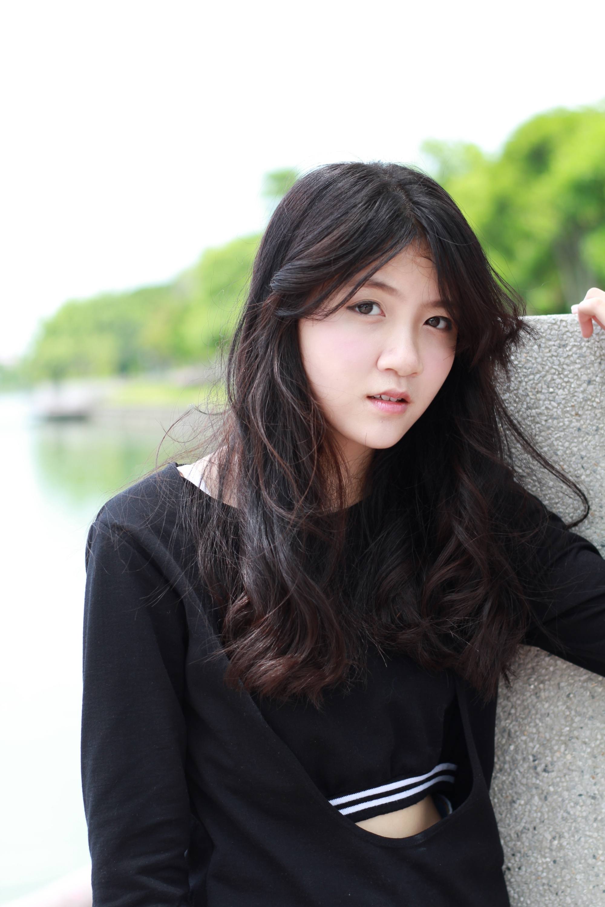 Asian woman with long hair wearing a black shirt