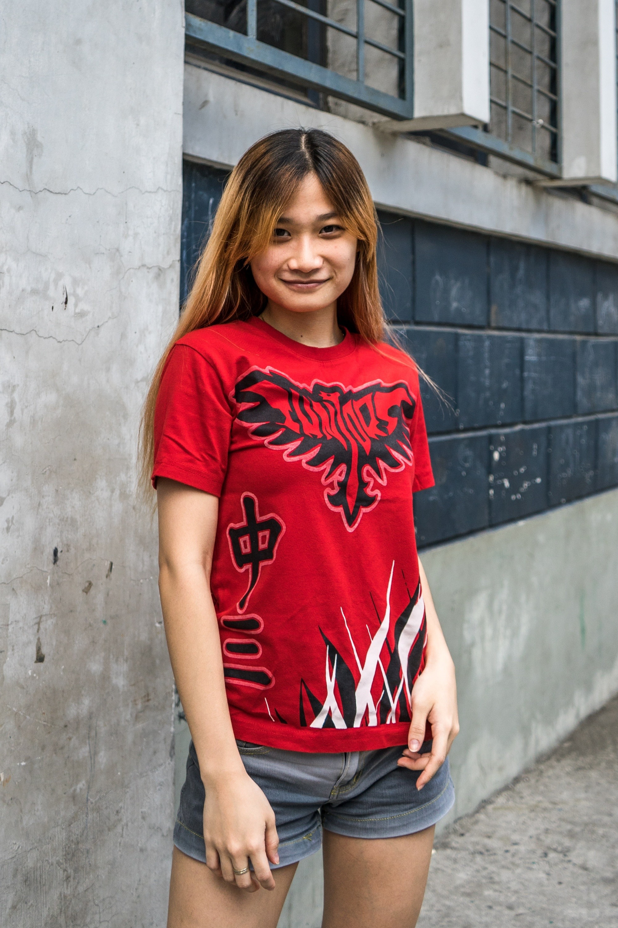 Asian woman with long hair wearing a red shirt