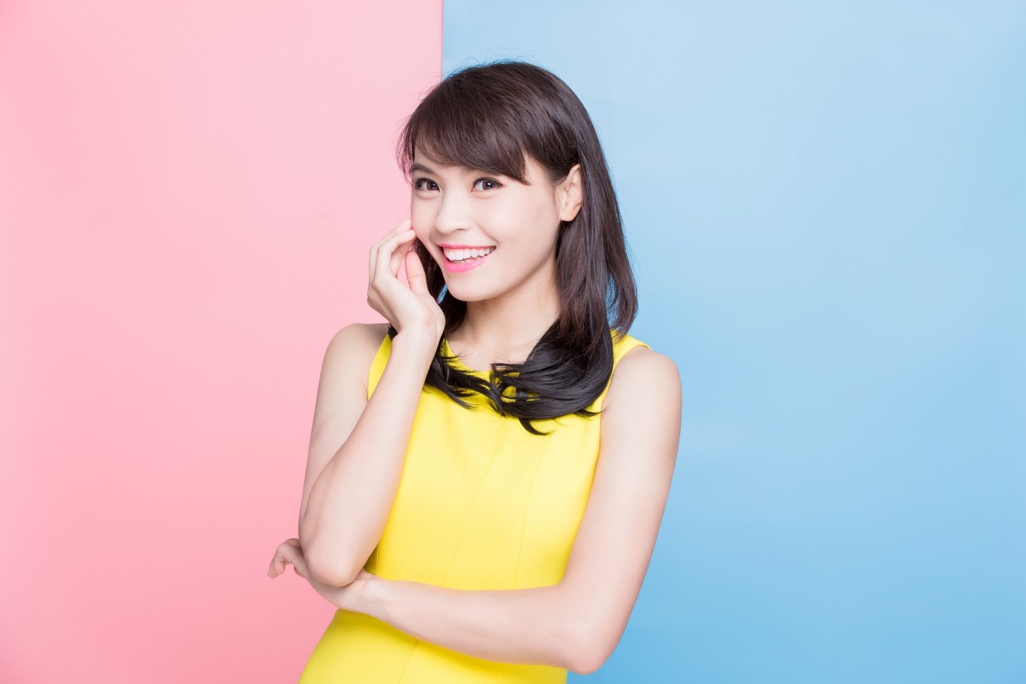 Asian woman with layered hair wearing a yellow dress