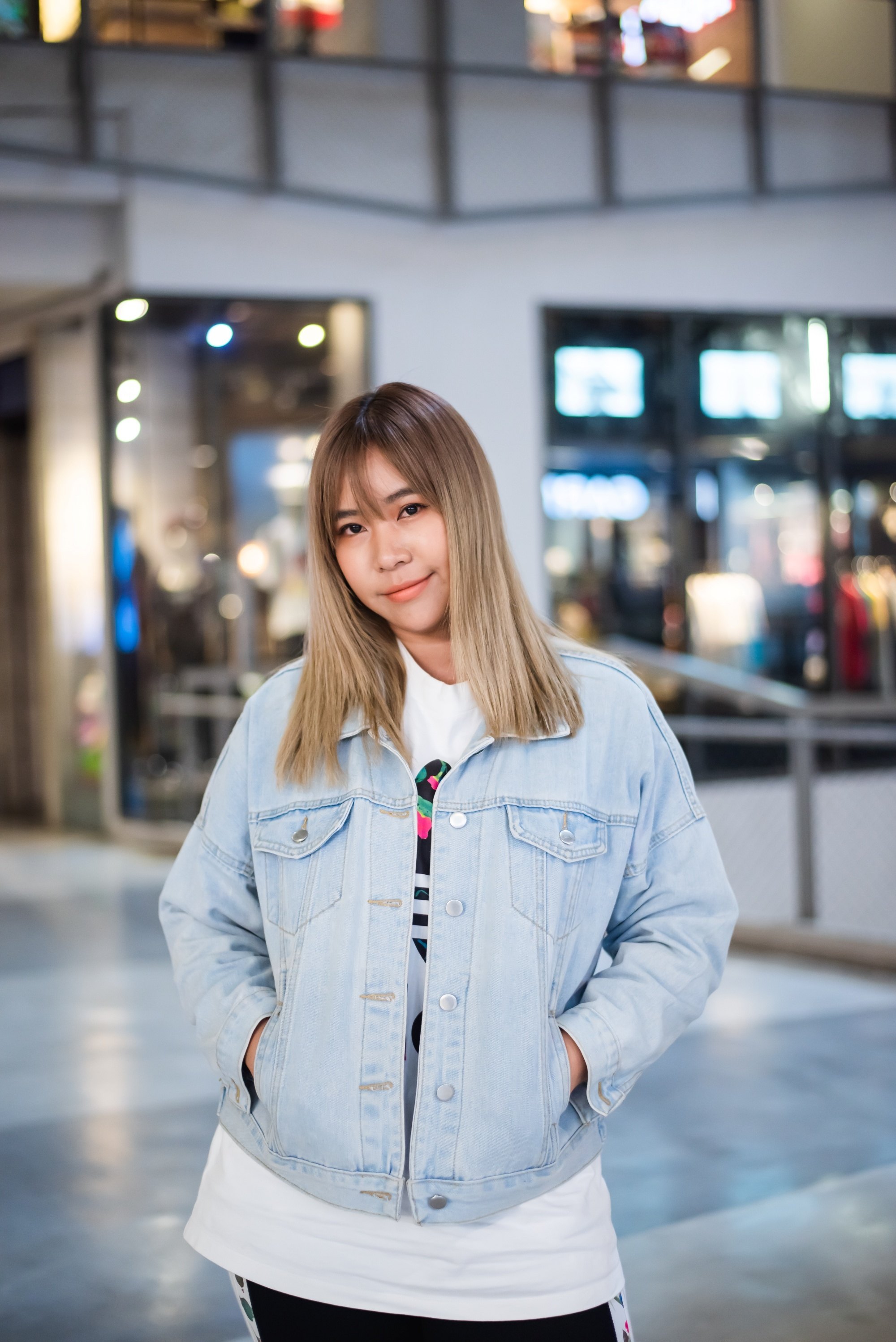 Asian woman with ash brown ombre hair wearing a denim jacket