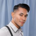 Asian man with side part undercut hairstyle wearing a polo and suspenders