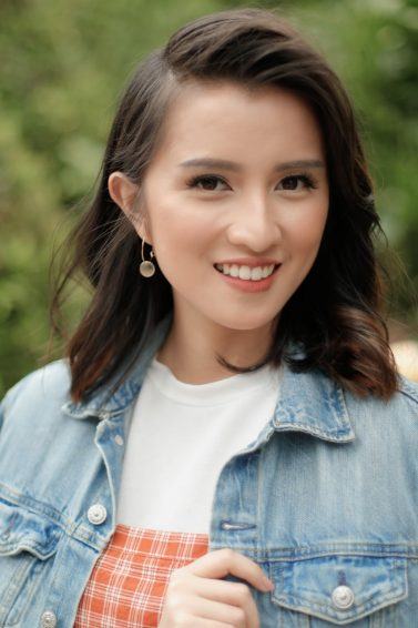 Asian woman with side bangs wearing a denim jacket