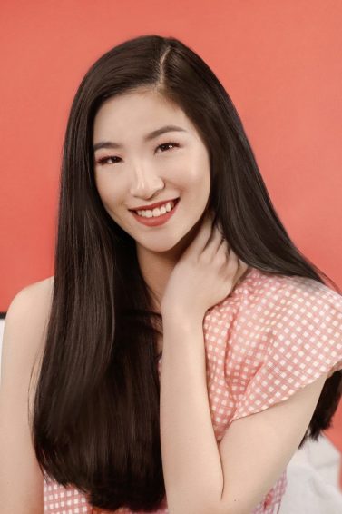 Asian woman with long black hair wearing a red top