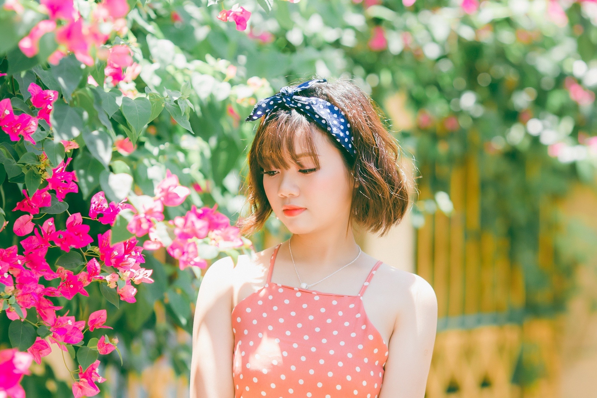 Asian woman with short hair with bangs wearing a blue headband
