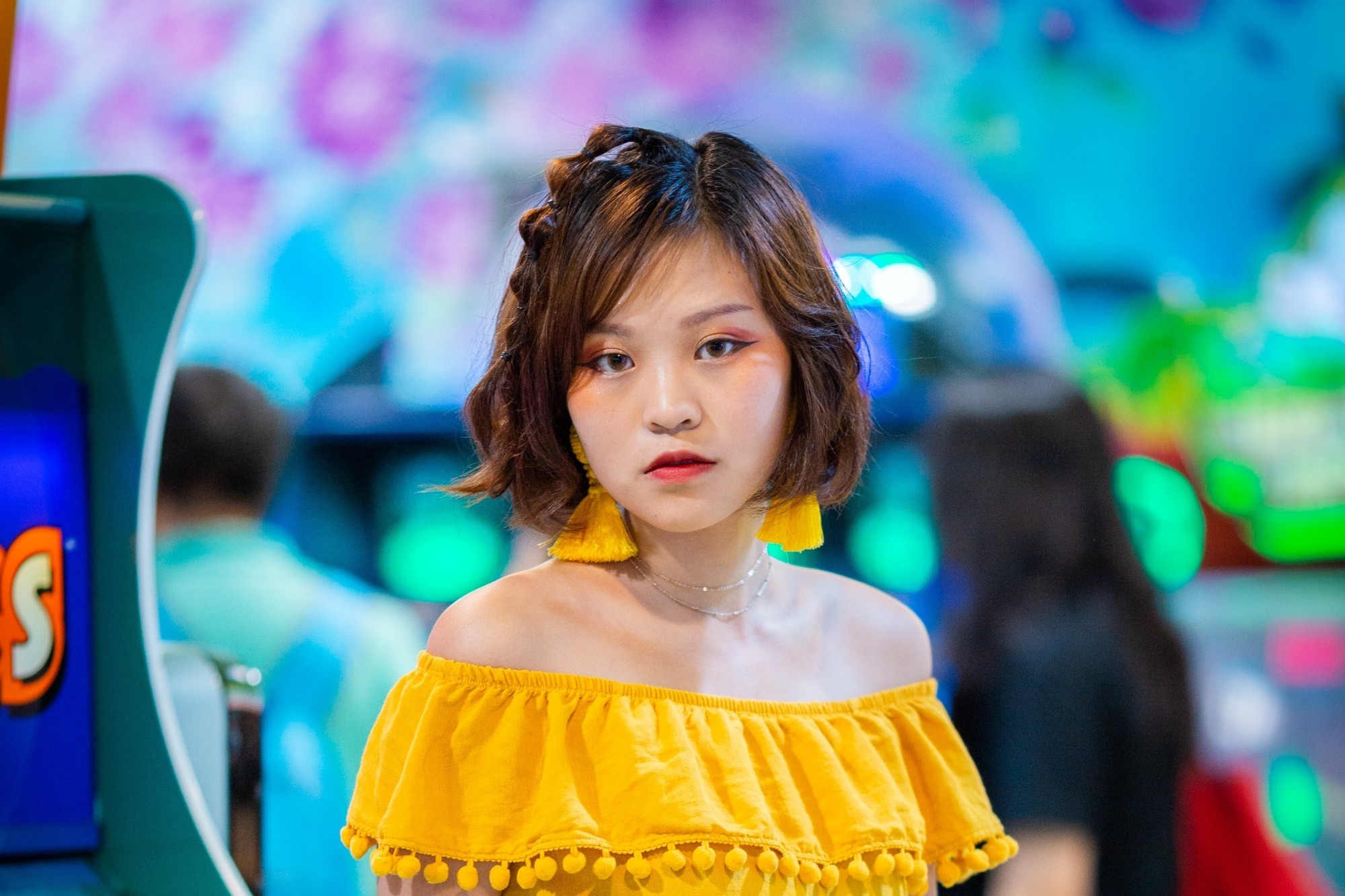 Asian woman with short hair wearing a yellow top