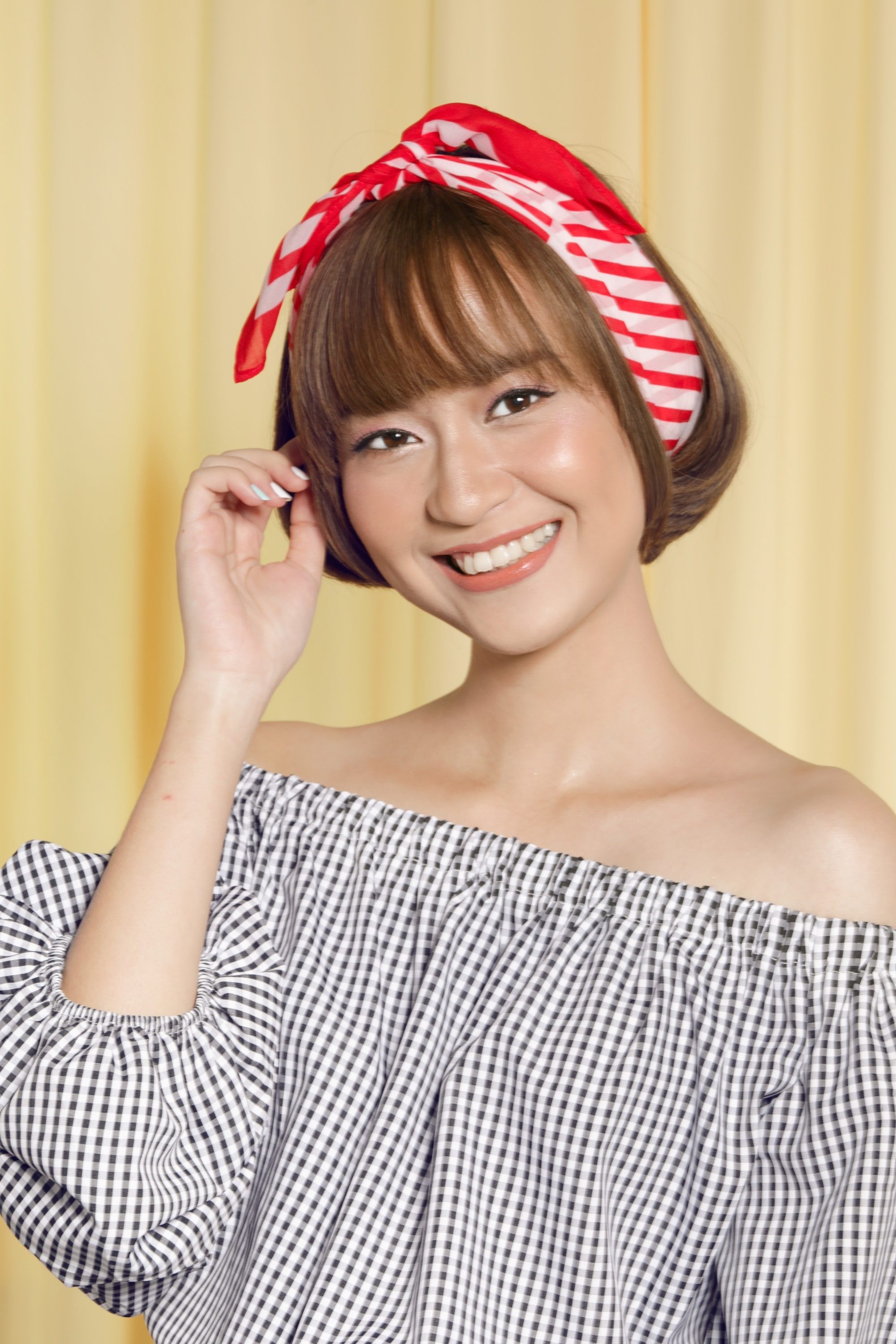Asian woman with chin-length hair with bangs wearing a headband