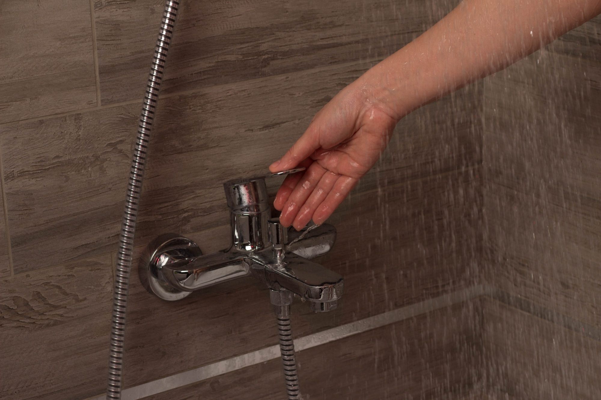 Closeup shot of a hand turning off the showet