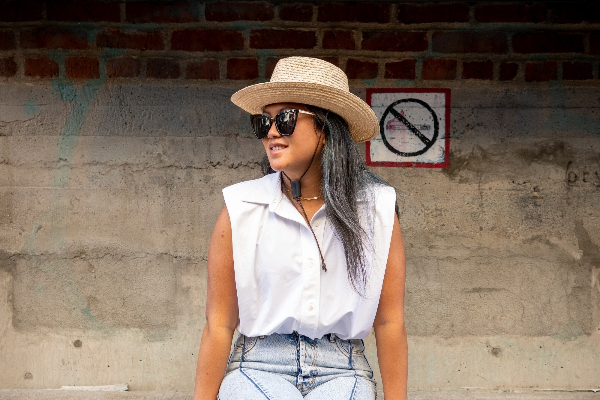Asian woman with ash gray hair for morena skin wearing a hat and white top