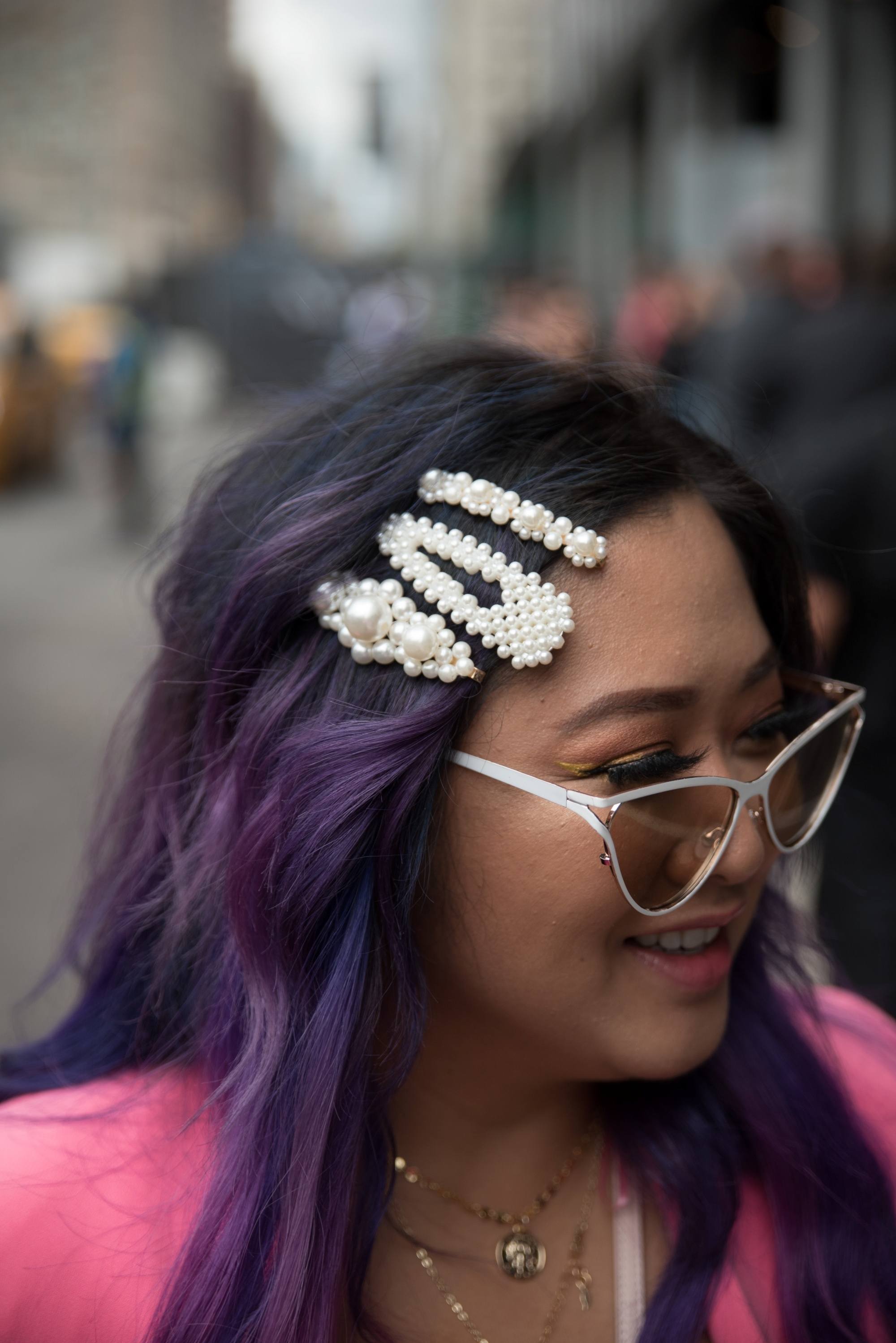 Asian woman with purple hair wearing white hair clips and sunglasses