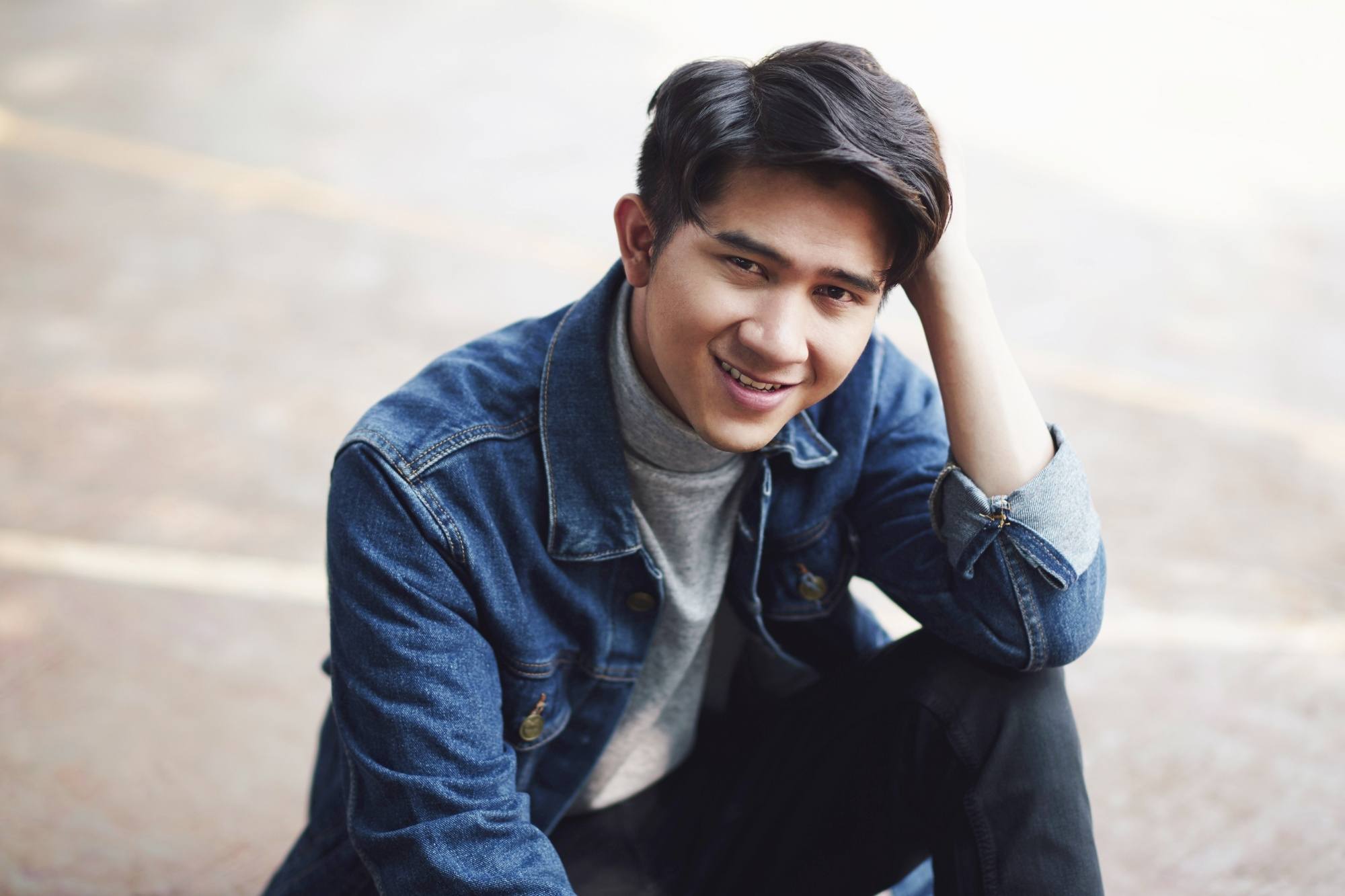 Asian man with Korean comma haircut wearing a denim jacket