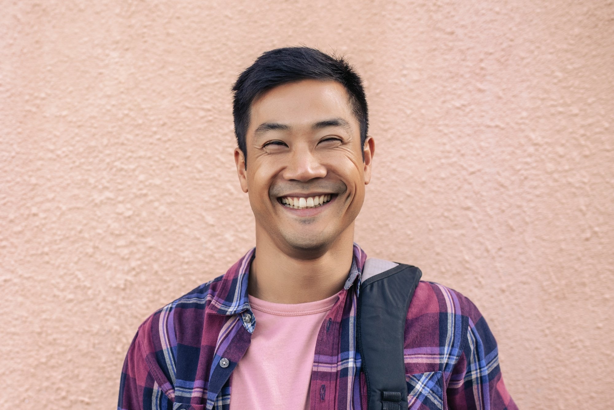 Asian man with a crew cut hair wearing a plaid jacket